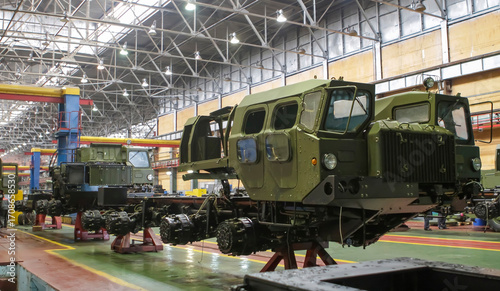 Production process at wheel tractor plant focusing on military equipment assembly in spacious factory setting
