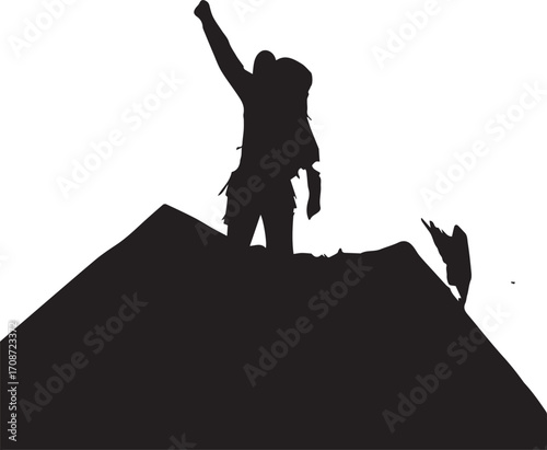 Silhouette of a triumphant hiker with raised fist on a mountain peak