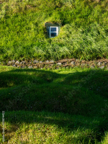 Green roof of traditional Icelandic turf house with window - Hof, Iceland
