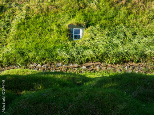 Green roof of traditional Icelandic turf house with window - Hof, Iceland