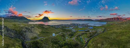 Flateyri village in Iceland Westfjords aerial panorama at sunset with colorful clouds calm fjord waters and dramatic surrounding mountains