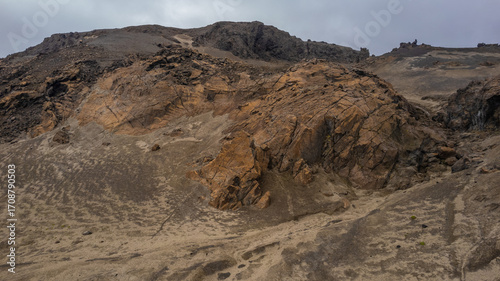 Harsh barren slopes of Icelandic highlands with exposed volcanic cliffs and weathered rocky terrain