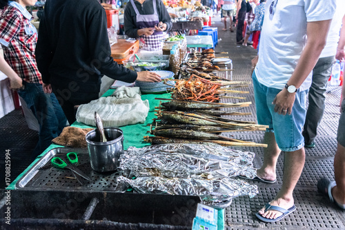 Tourists choosing grilled fish at a market in phnom penh, cambodia