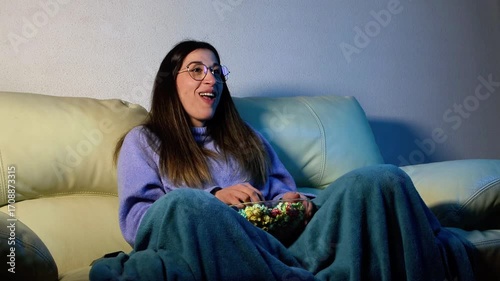 Young woman enjoying movie night with popcorn on sofa