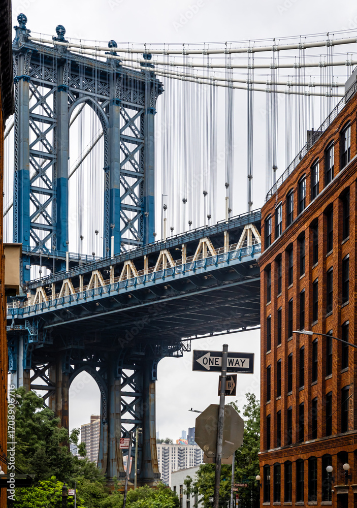 Naklejka premium Manhattan Bridge view framed by red brick buildings in DUMBO Brooklyn