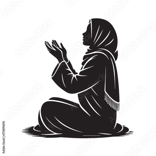 Silhouette of a muslim woman wearing a hijab and traditional clothing kneeling and praying with her hands raised in supplication