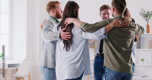 Happy business people team embraces each other, providing support during a psychotherapy session in the office. Solidarity and support exemplifies the strength of teamwork in challenges.