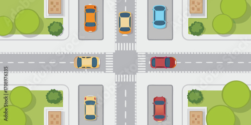Aerial view of a city intersection with cars driving and parked on a sunny day