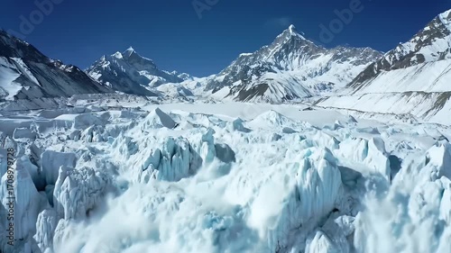 Aerial View of a Spectacular Icefall on a Snowy Mountain Under Clear Blue Sky