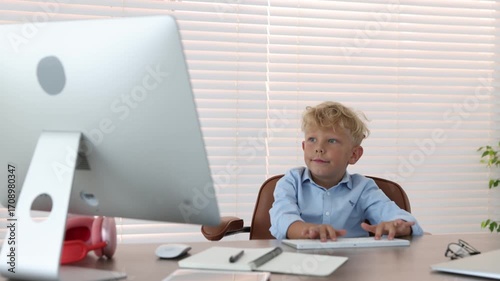 Choice of profession. Little boy pretending to work on computer in office