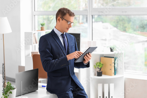 Papier peint Handsome businessman working with tablet computer in office