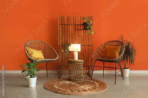Foto Interior of stylish living room with chairs, houseplants and glowing lamp on cof