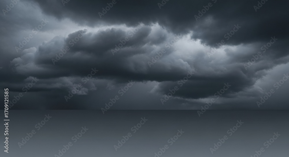 Obraz premium Dark and ominous storm clouds gather over a flat horizon, creating a dramatic and moody skyscape before a downpour.