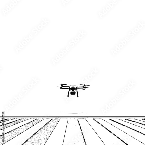 A drone hovers above a field with parallel lines creating a stark contrast in a black and white composition