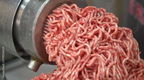 Fresh meat being ground in a food processing machine