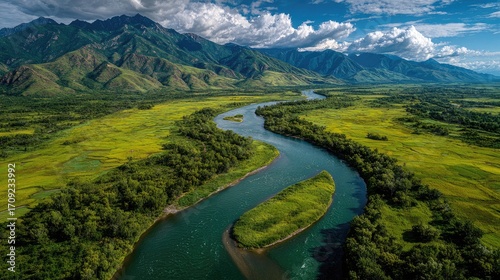 Scenic river winding through lush valley, mountains in background