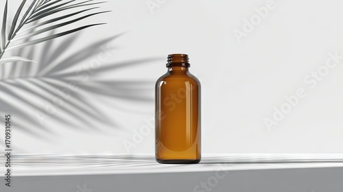 Amber glass bottle on a minimalist white surface, subtly lit, with a palm frond shadow casting to the left