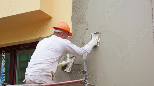 Construction worker plastering cement on wall, professional builder applying plaster layer for house renovation, masonry finishing process concept, construction site repair maintenance, building indus
