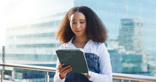 Photos Business woman, tablet and reading outdoor with analysis, review or research for economic report in city