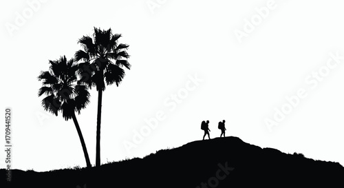 Silhouette of two people walking on a hill with palm trees
