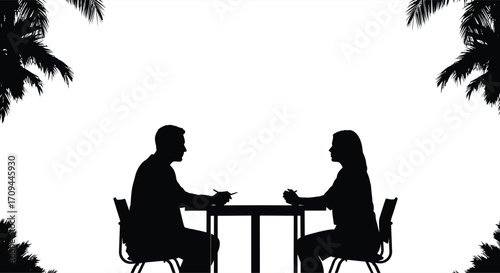 Silhouetted couple enjoying a meal together at a table outdoors