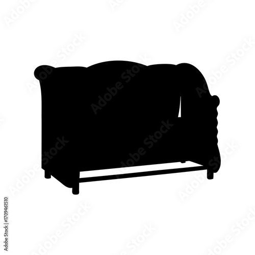 Silhouette of an ornate vintage sofa with a draped blanket on it