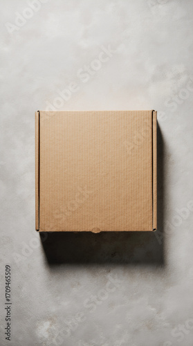 Plain square pizza box closed on a matte stone background, top-down mockup-ready studio shot with soft edge shadow