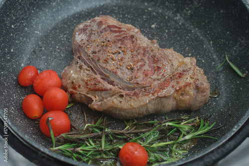 Pan-fried steak with red tomatoes and rosemary