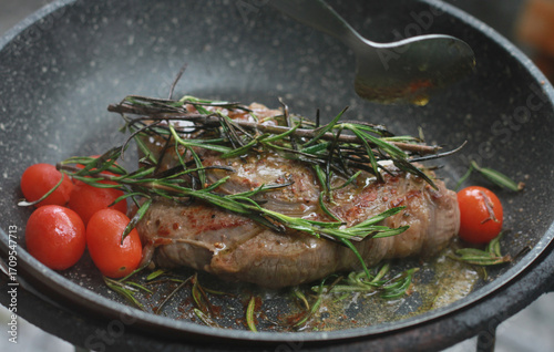 Pan-fried steak with red tomatoes and rosemary