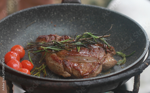 Pan-fried steak with red tomatoes and rosemary