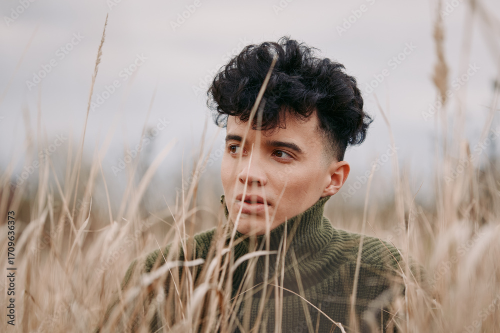 Φωτογραφία Candid portrait of a young person amid tall dry grass, contemplative gaze and soft natural light conveying authenticity and genuine emotion, close framed, neutral tones and textured surroundings