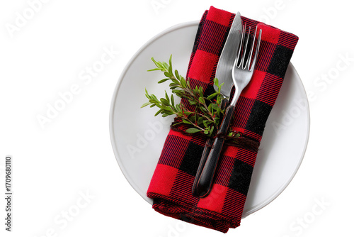 Festive table setting with red and black checkered napkin, cutlery, and herbs