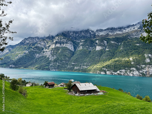 Scenic view of Swiss valley with lake and mountains under cloudy sky