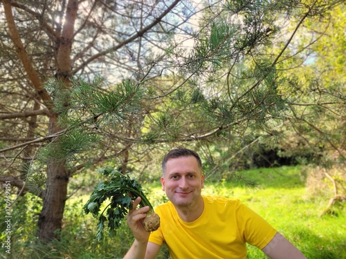 Smiling man holding raw celery root