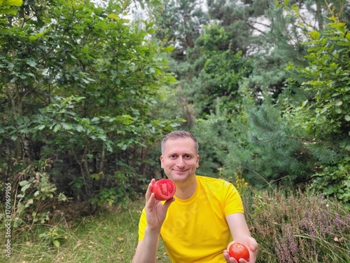 Smiling man holding two tomatoes