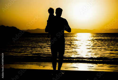 A father and child silhouette stands on the beach, with the child on the father's shoulders, bathed in the breathtaking sunset light.
