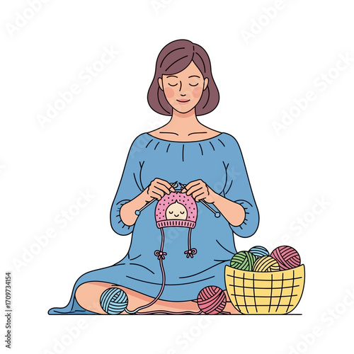 Pregnant woman serenely knits a baby hat, surrounded by colorful yarn.