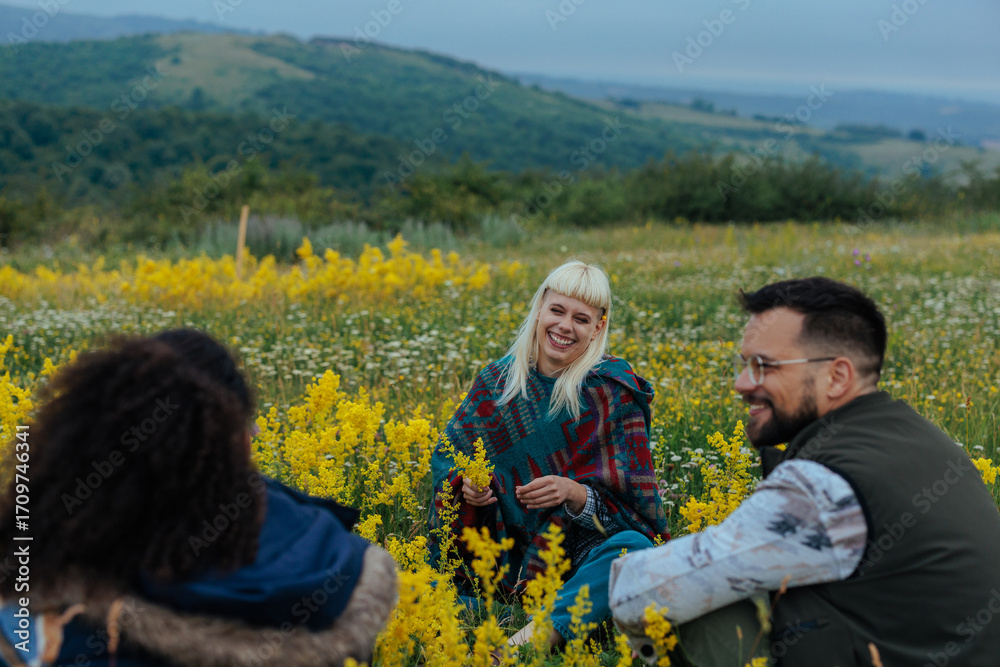 Fototapeta premium Three people enjoying themselves on a meadow in the hills