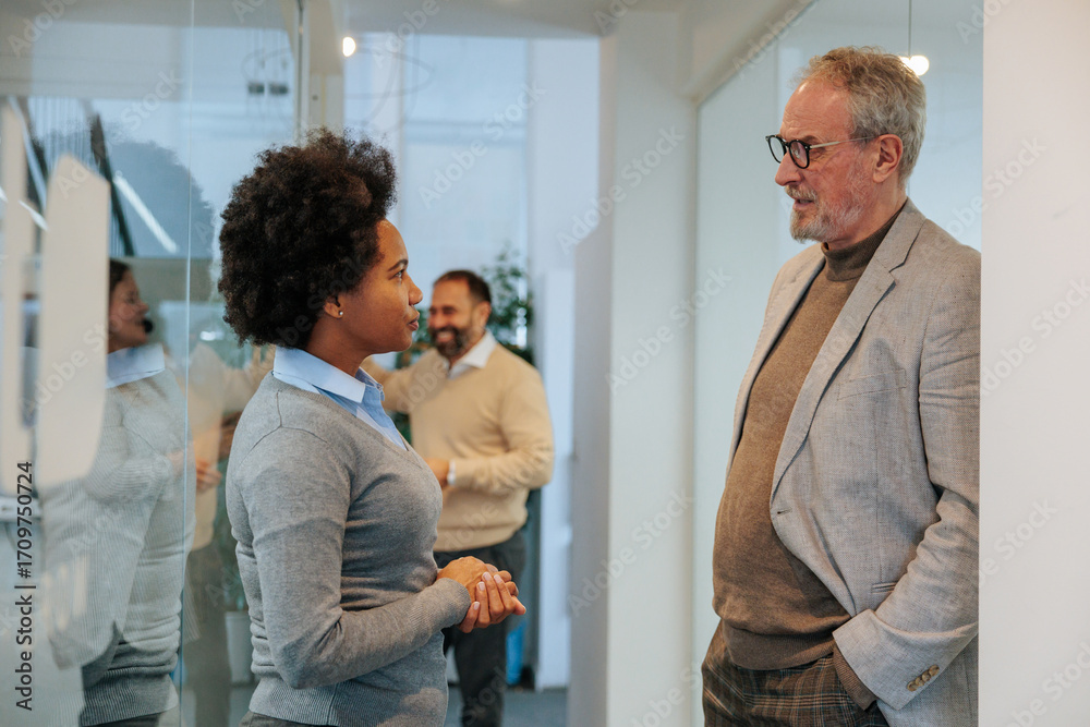 Fototapeta premium Colleagues standing in the hallway talking