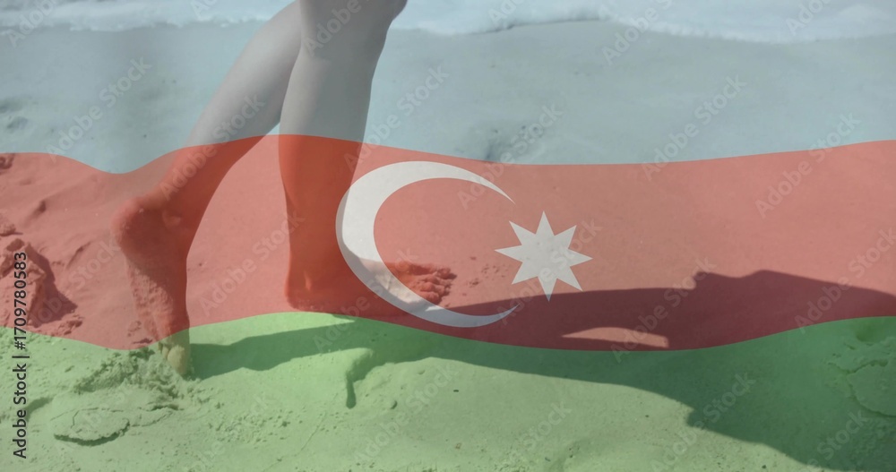 Fototapeta premium Walking bare lower legs and feet along sandy beach shoreline, with Azerbaijan flag overlay