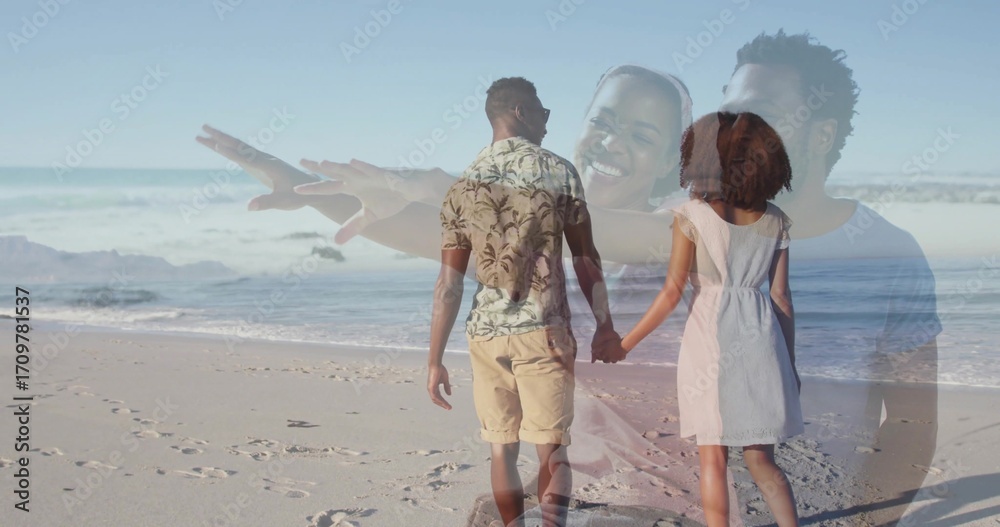 Obraz premium Walking couple holding hands along sandy shoreline, with footprints and gentle ocean waves