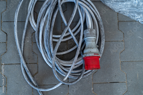 Foto Coiled industrial power cable with red CEE connector