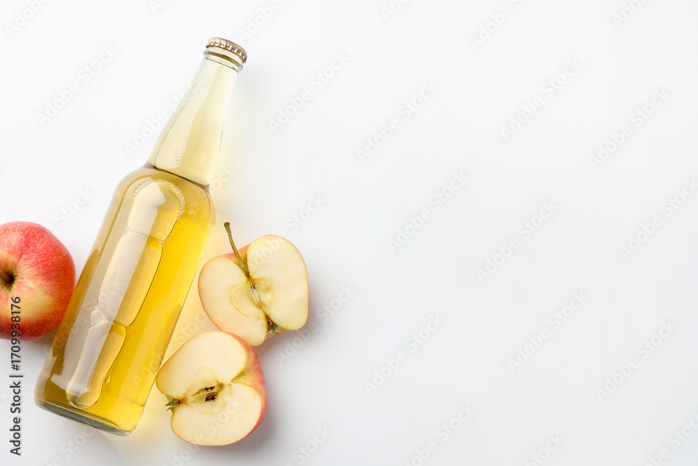 Fototapeta premium Delicious cider in glass bottle and apples on white background, flat lay. Space for text