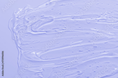 Transparent cosmetic cream gel on a lilac background. Abstract violet background.