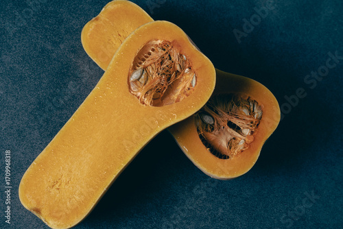 Butternut squash cut in half. On a gray background close-up. With many small details.  Halloween.
