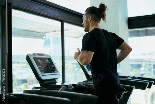 Wallpaper Mural Young man running on treadmill in the gym Torontodigital.ca