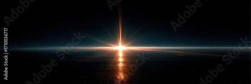 A bright light source radiates across a dark body of water, reflecting into the sky, horizon visible