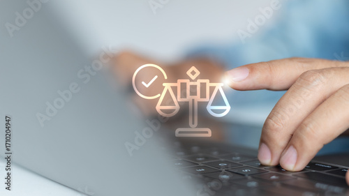 Billede på lærred Close-up hand using a laptop with a digital justice balance icon and check mark