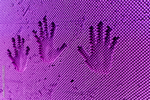 Bild auf Leinwand A captivating pattern of hand impressions pressed into a field of purple pins