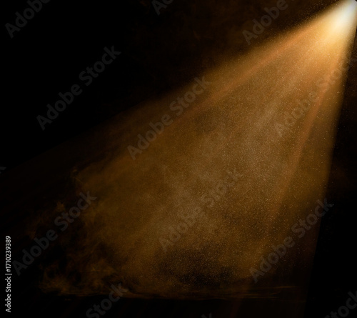 Golden light beam illuminating dust particles in dark room